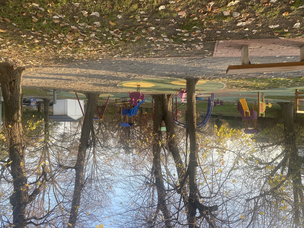 Park and playground reflected in water